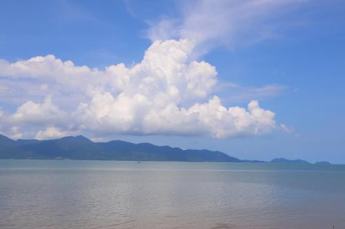a cloud over the water with mountains in the background at Ban Sulada Guest House in Laem Ngop