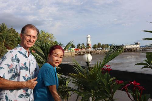 a man and a child standing next to a lighthouse at Ban Sulada Guest House in Laem Ngop
