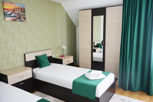 a bedroom with two beds and a mirror at Pensiunea Royal in Borşa