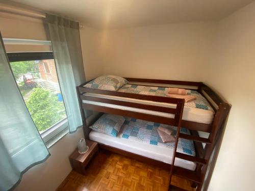two bunk beds in a room with a window at Apartment Konavec in Kobarid