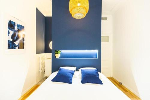 - une chambre avec un lit blanc aux murs bleus dans l'établissement 3 min à pied de la gare St Charles - 3 chambres avec Clim, SDB et TV, à Marseille