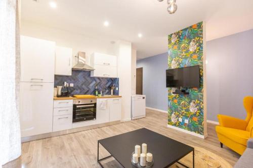 - une cuisine avec des placards blancs et une table dans le salon dans l'établissement 3 min à pied de la gare St Charles - 3 chambres avec Clim, SDB et TV, à Marseille