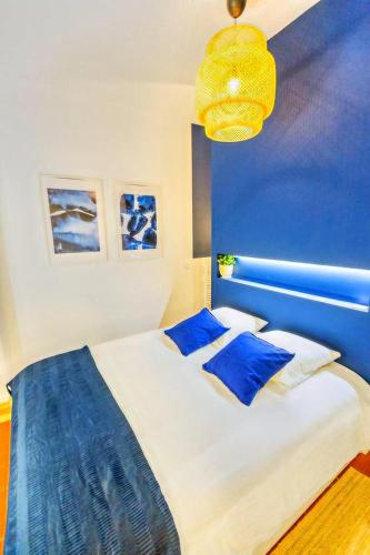 - une chambre dotée d'un mur bleu et d'un lit avec des oreillers bleus dans l'établissement 3 min à pied de la gare St Charles - 3 chambres avec Clim, SDB et TV, à Marseille