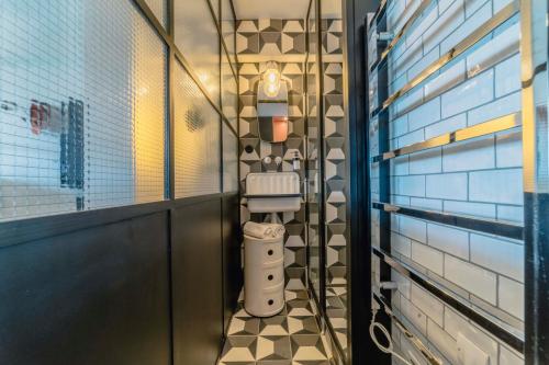 a bathroom with a toilet in a room with tiled walls at Alaena, vue imprenable sur l'océan in Biarritz