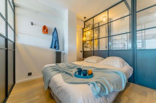 a bedroom with a bed with a tray on it at Alaena, vue imprenable sur l'océan in Biarritz