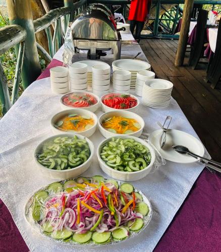 a table with bowls of vegetables on a table at Mara Sweet Acacia Lodge in Talek