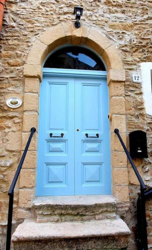 a blue door in a stone building with stairs at Casa Santa Maria - Beautifully restored house in centro storico Irsina Basilicata Puglia in Irsina