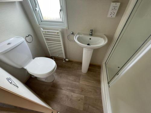 a bathroom with a toilet and a sink at PG177 Golden Palm Resort 8 Berth Caravan With Decking in Chapel Saint Leonards