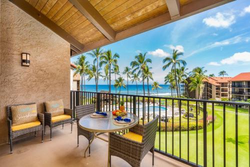 a balcony with a table and chairs and a view of the ocean at Papakea K406 OceanView 2 Bedroom 2 bath condo in Kahana