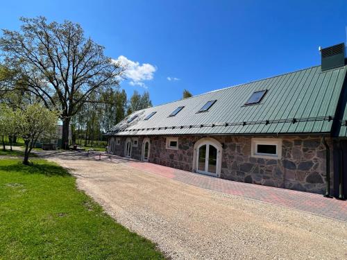 a stone barn with a gravel road in front of it at Valgesoo maakivivilla kuni 20-le kylalisele in Valgesoo