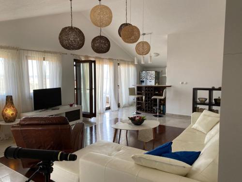 uma sala de estar com um sofá branco e uma televisão em Villa Ecosse em Murter