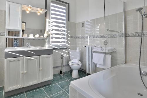 ein Badezimmer mit einer Badewanne, einem WC und einem Waschbecken in der Unterkunft Logis Hôtel-Restaurant Les Voyageurs in La Coquille