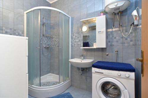 łazienka z prysznicem i pralką w obiekcie Apartments Branislav 1927 w mieście Vinkuran