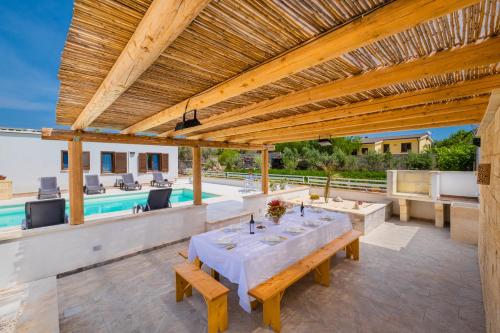 an outdoor patio with a table and a pool at Dependance Specchia with Pool in Specchia