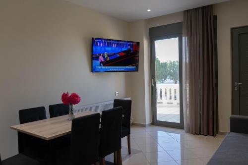 a dining room with a table and a tv on the wall at Gramvoussa Bay in Kissamos