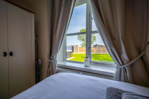 a bedroom with a window with a view of a yard at The Stables in Halesworth