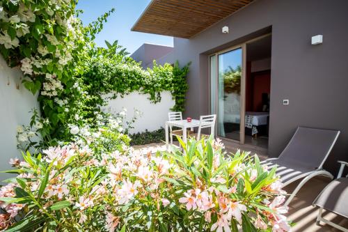 a patio with a table and chairs and flowers at Villa Jardins D'Isa in Marrakech