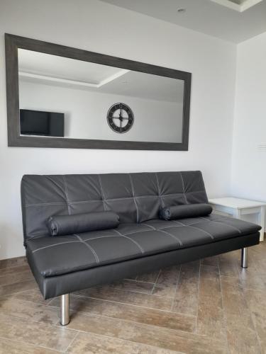 a black leather couch in a room with a mirror at Port Royale MONTANA in Arona