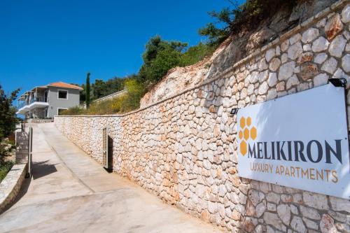 a sign on the side of a stone wall at MELIKIRON LUXURY APARTMENTS in Agios Nikitas