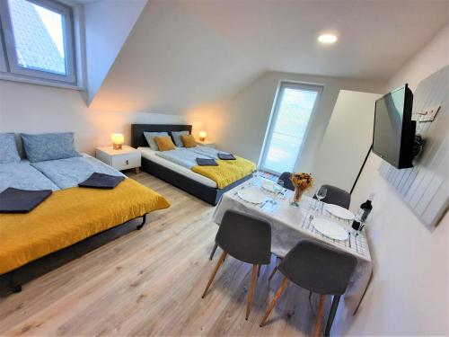 sypialnia z 2 łóżkami, stołem i kanapą w obiekcie Tatras Apartments 622 w Nowej Leśnej
