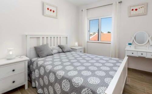 um quarto branco com uma cama e uma janela em Sofiamar Holidays Casa da Paula em Pêra