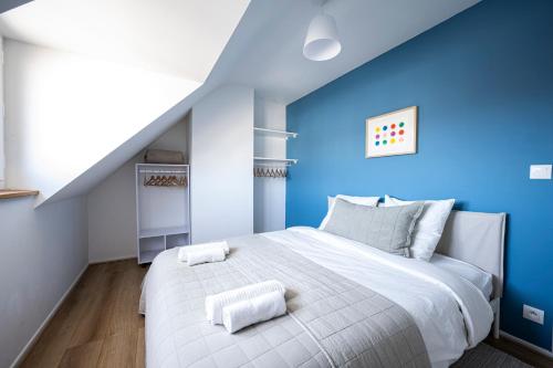 una camera da letto con un grande letto bianco e pareti blu di IDEAL PRO - 10min gare - Hypercentre - WIFI - Longuedurée a Pau