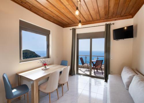 a living room with a table and chairs and a couch at MELIKIRON LUXURY APARTMENTS in Agios Nikitas
