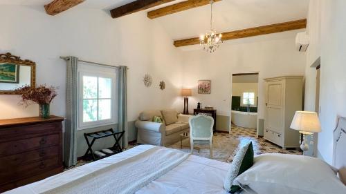 a bedroom with a bed and a living room at Domaine de La Brave in Pernes-les-Fontaines