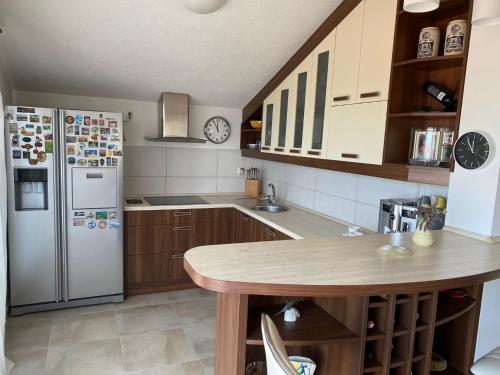 a kitchen with a refrigerator and a table in it at Villa Ecosse in Murter