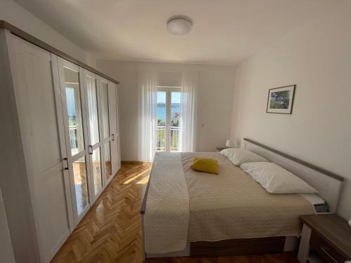 ein Schlafzimmer mit einem Bett und einem großen Fenster in der Unterkunft Apartments Roko in Turanj