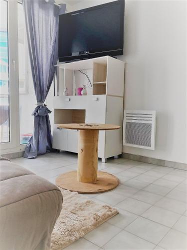 un salon avec une table et une télévision dans l'établissement Proche Mer Nice Coquet 2P 28m², à Nice