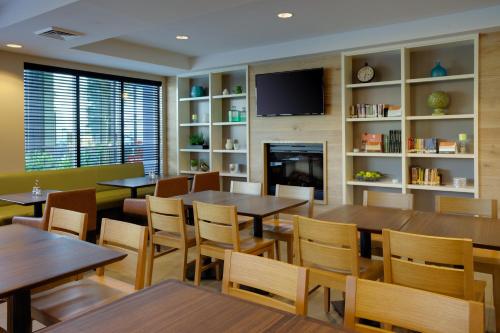 un ristorante con tavoli, sedie e un camino di Country Inn & Suites by Radisson, Frederick, MD a Frederick