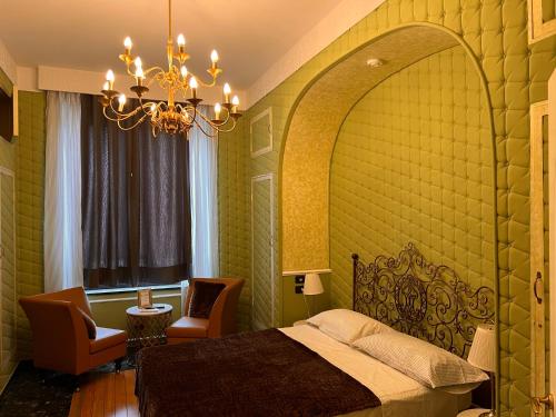 a bedroom with a bed and a chandelier at Villa Camilla Milano in Milan