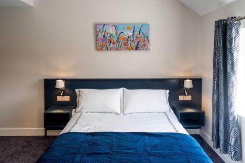 a bedroom with a bed and a painting on the wall at Bridge Inn Studio Apartments in Donegal