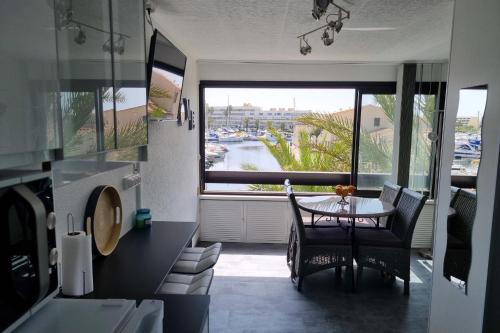 - une cuisine avec une table et une vue sur le port dans l'établissement Naturiste Cap d'Agde Port Vénus 110, au Cap d'Agde