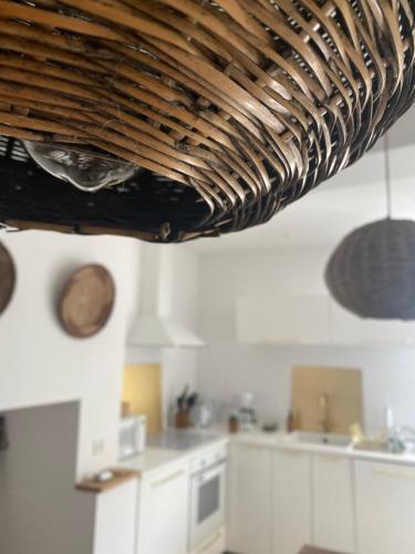 a kitchen with white cabinets and a wooden ceiling at Lou Mut in Lectoure