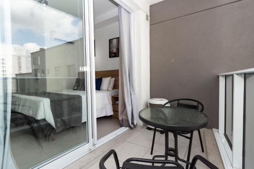 a small balcony with a table and a bedroom at 360 Suítes Sé in Sao Paulo