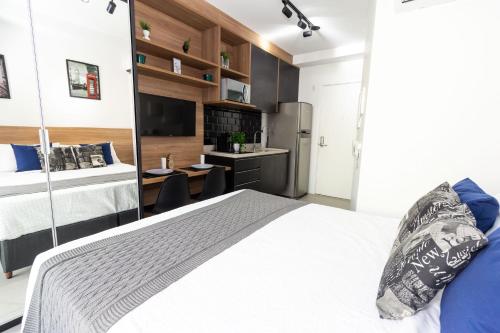 a bedroom with a large bed and a desk at 360 Suítes Sé in Sao Paulo