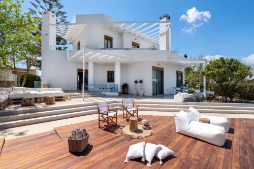 a house with white furniture on a wooden deck at Love White Villa in Ialysos