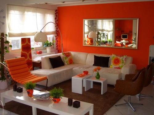 ハノーファーにあるABT プライベート アパートメンツ ハノーバー エキシビション グラウンド (ルーム エージェンシー) の白いソファとオレンジ色の壁が備わるリビングルーム