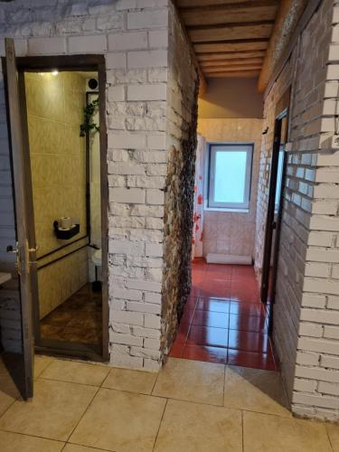 an empty hallway with a brick wall and a door at Brīvdienu māja Rozes in Jūrkalne