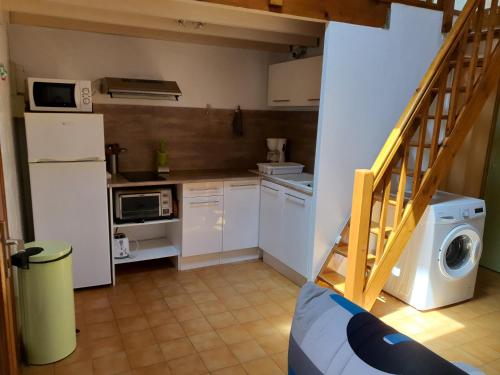 uma pequena cozinha com armários brancos e uma máquina de lavar e secar roupa em Villa MJP 463 em Narbonne Plage