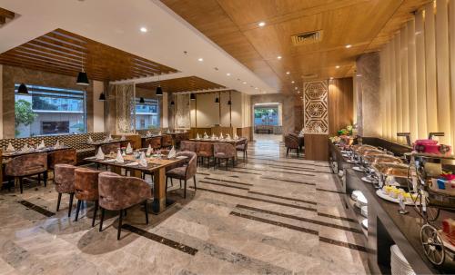 - un restaurant avec des tables et des chaises dans une salle dans l'établissement Lords Inn Jaipur, à Jaipur
