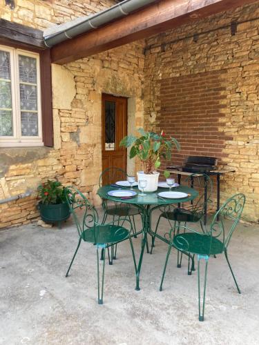 d'une table et de chaises avec une plante sur la terrasse. dans l'établissement maison de campagne en pierre, à Dégagnac