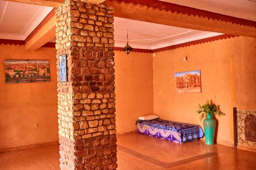 a room with a stone pillar with a bed in it at Auberge Restaurant Telouet in Telouet