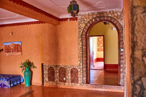 a room with a stone wall with a mirror at Auberge Restaurant Telouet in Telouet