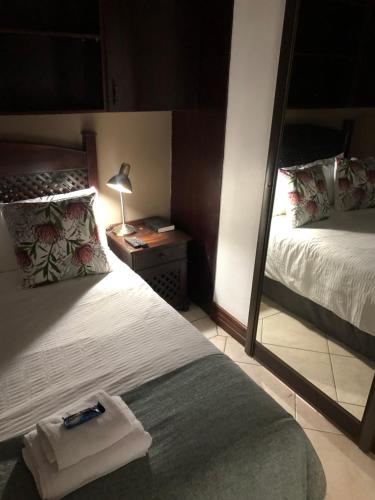 um quarto com um espelho, uma cama e um espelho. em Casa Flora Guesthouse em Pretoria