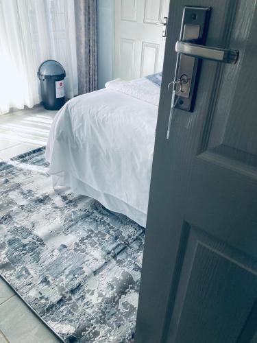 a bedroom door with a bed and a rug at President Guest Lodge in Louis Trichardt