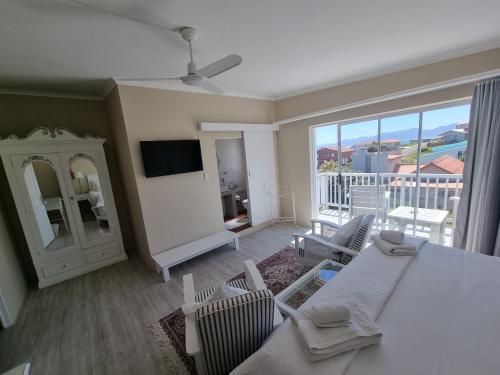 a living room with a table and chairs and a television at The Bay Lodge in Gansbaai