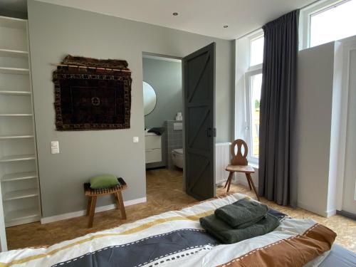 een slaapkamer met een groot bed en een spiegel bij Stoomzicht in Wijlre
